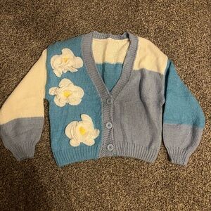 Blue block sweater with crocheted flowers